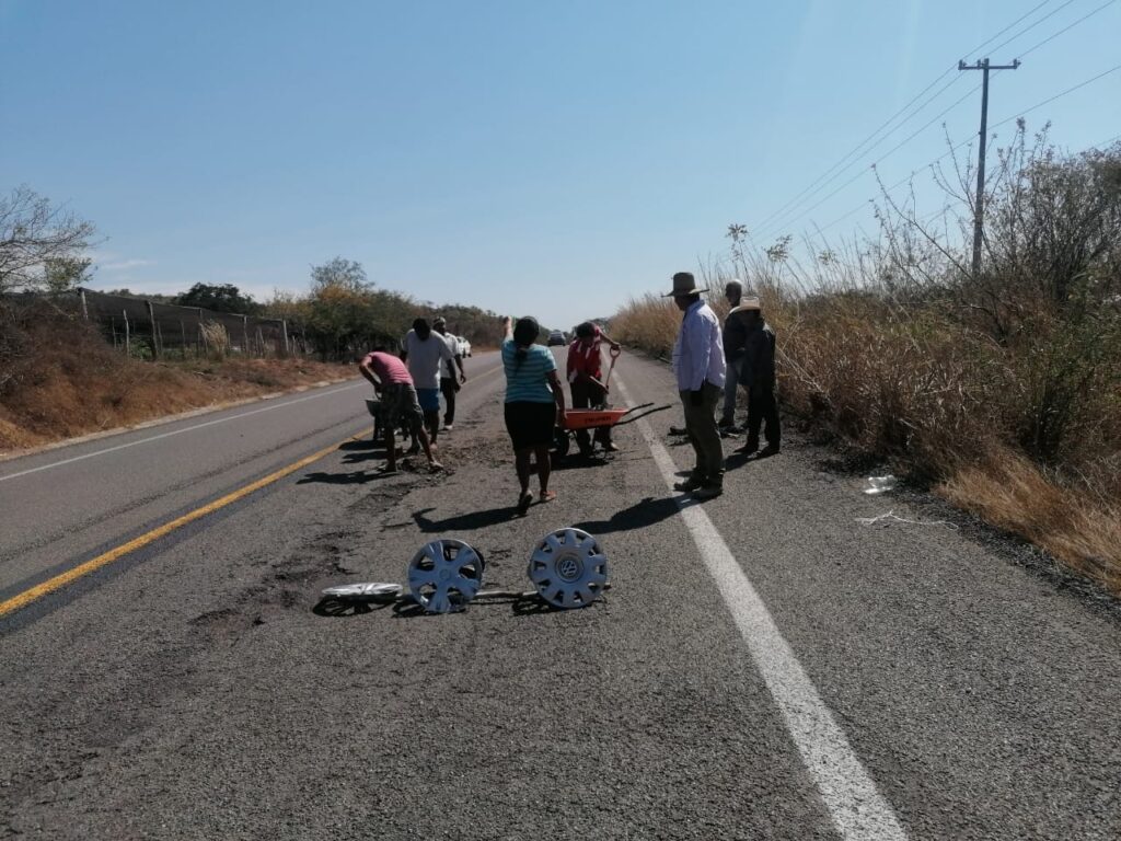 Por su cuenta, habitantes reparan carretera Zihuatanejo-Feliciano