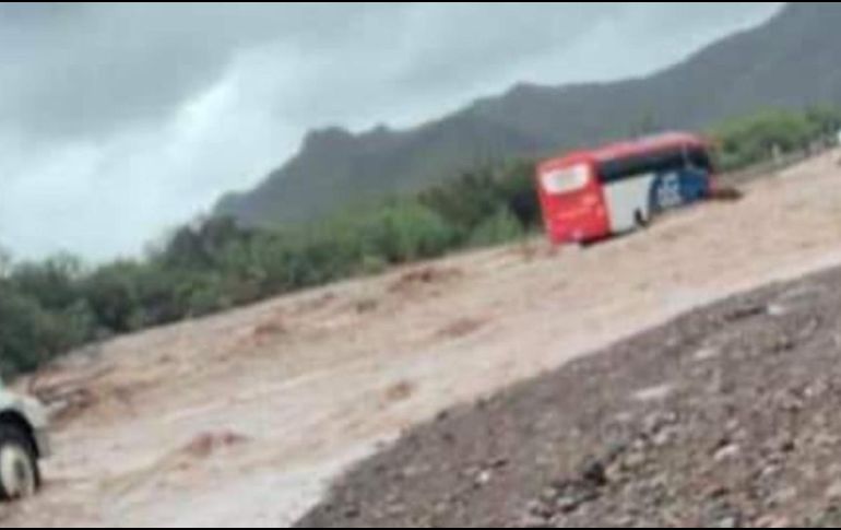 En Baja California, un autobús con pasajeros es arrastrado por arroyo