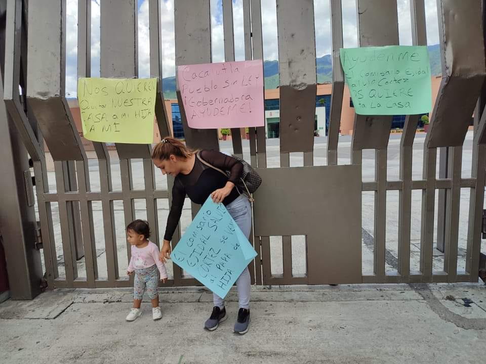 Con pancartas piden no despojar de su propiedad a una ama de casa y su pequeña hija en Cacalutla