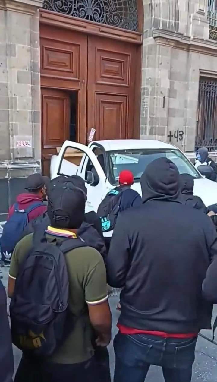Normalistas derriban puerta de Palacio Nacional en protesta por los 43 normalistas de Ayotzinapa