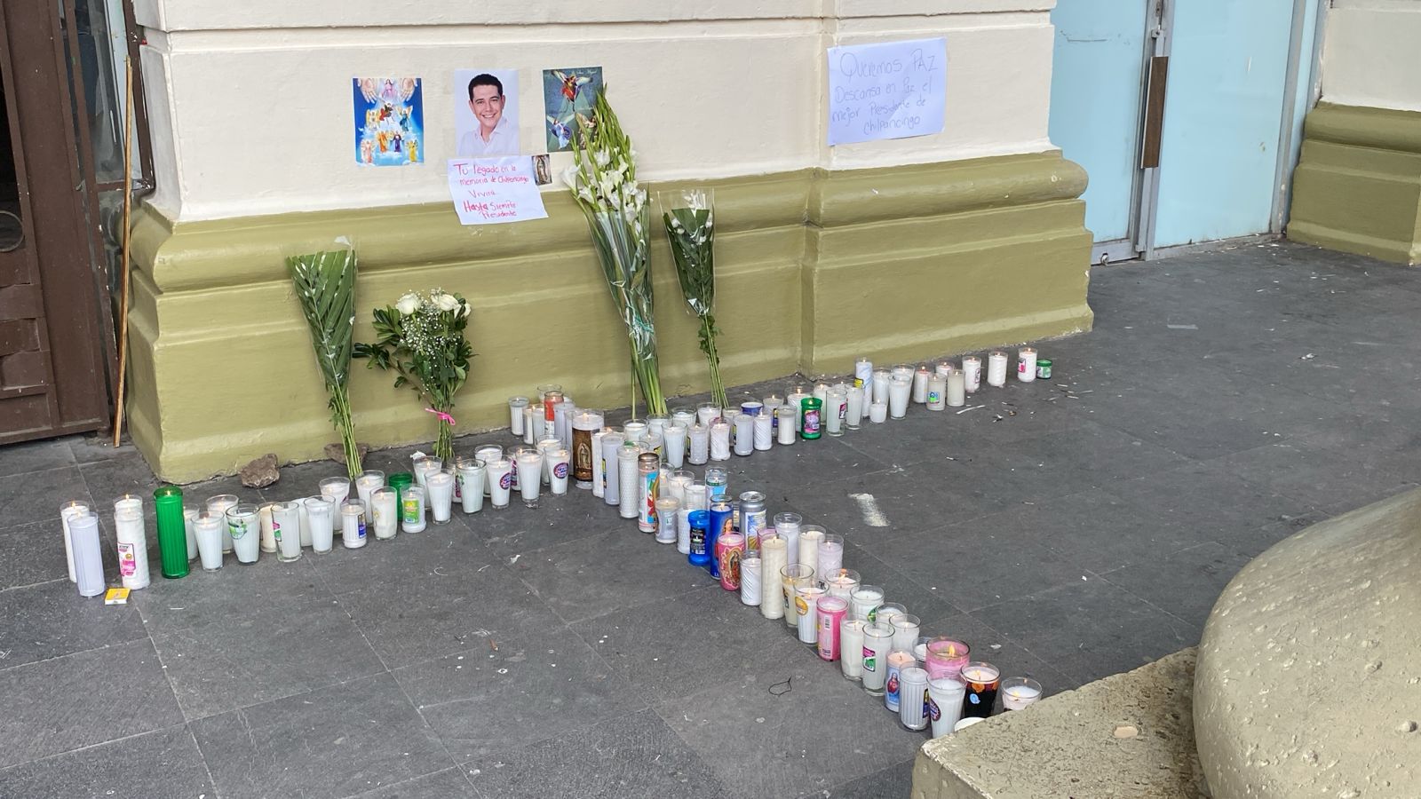 Colocan ciudadanos veladoras y foto de Alejandro Arcos al lado de acceso al Palacio Municipal