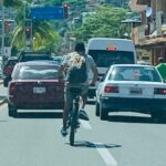 Ciclistas conducen entre vehículos sin equipo de protección personal